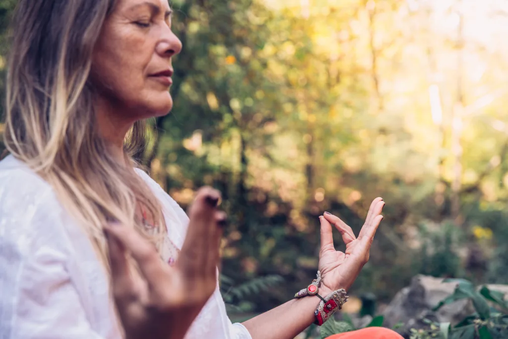 grounded morning routine mature woman meditating in forest
